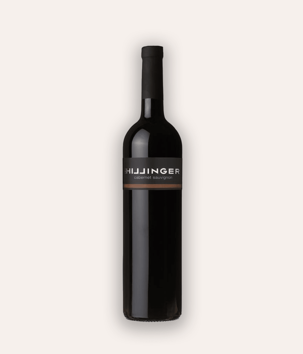 Weinflasche Hillinger Cabernet Sauvignon 2016 – dunkle Glasflasche mit schwarzer Kapsel, schwarzes Etikett mit weißer HILLINGER-Schrift und bronzefarbenem Cabernet Sauvignon-Schriftzug