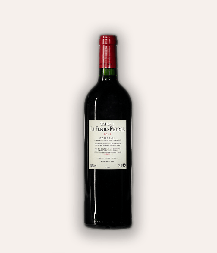 Rückseite der Weinflasche Château La Fleur-Pétrus 2017 Pomerol – dunkle Bordeaux-Flasche mit roter Kapsel, weißes Rücketikett mit Aufschrift Château La Fleur-Pétrus 2017 Pomerol Appellation Pomerol Contrôlée, 14,5% Vol., 75cl