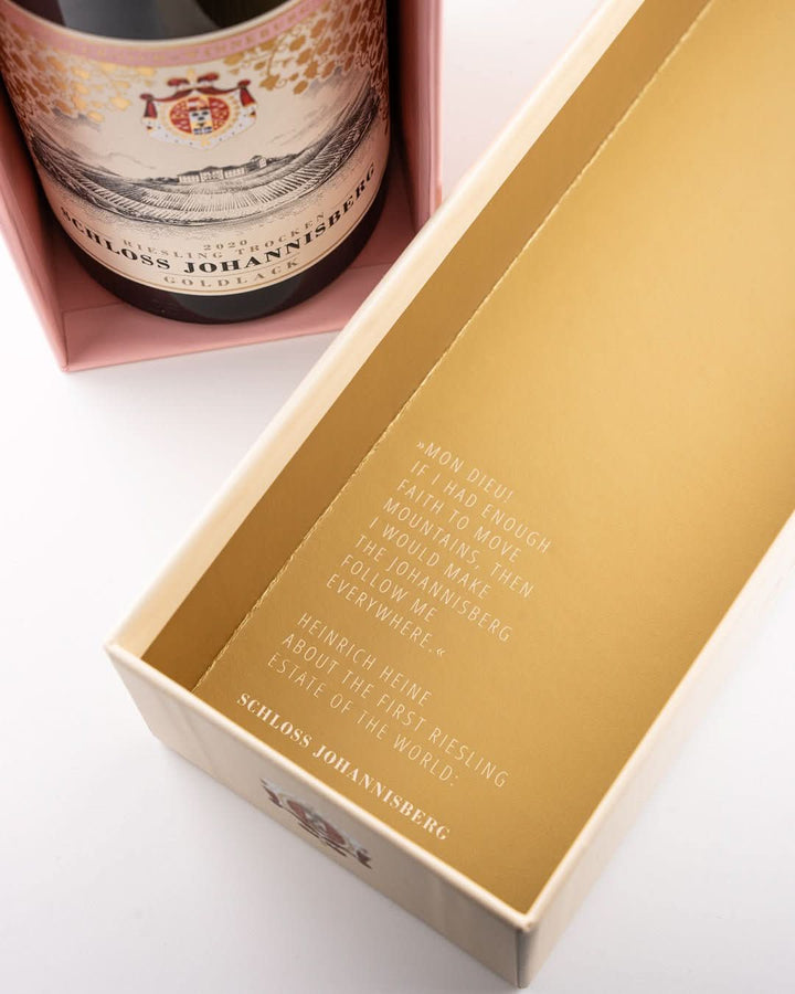 Weinflasche Schloss Johannisberg Riesling Goldlack 2020 in geöffneter pinker Geschenkbox, ornamentales Etikett mit Wappenschild; Außencover mit Kupferstich und Aufschrift The First Riesling Estate of the World